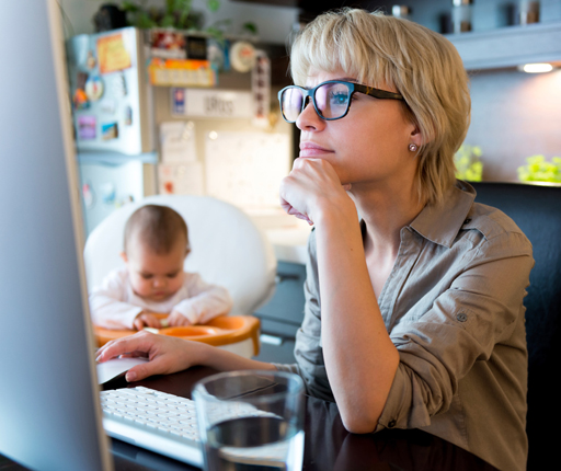 mother using computer in kitchen